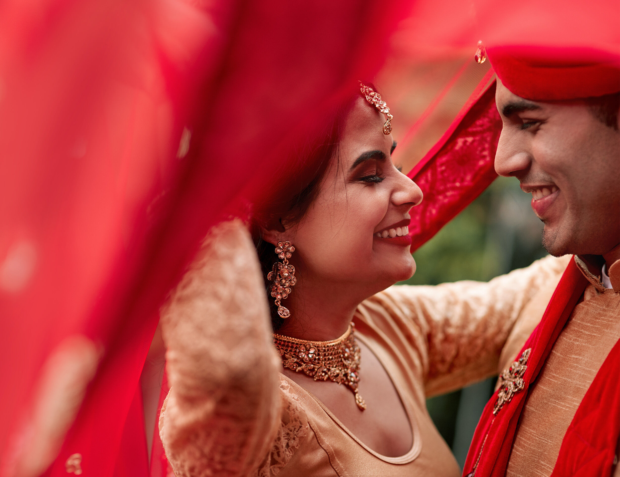 Happy Indian bride and groom laughing together during their wedding celebrations.